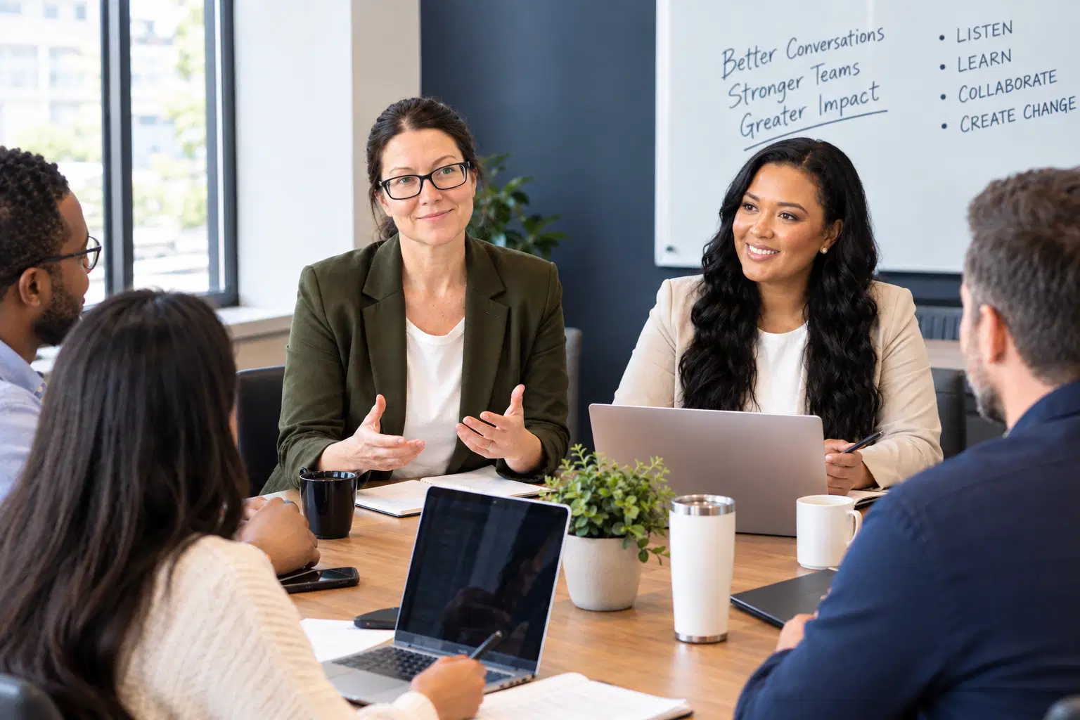 A diverse team in conversation around a table in a modern meeting room